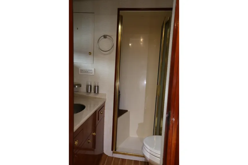 Slide: The Image of 1981 Bertram Convertible yacht bathroom with shower, sink, and wooden cabinetry. - 66