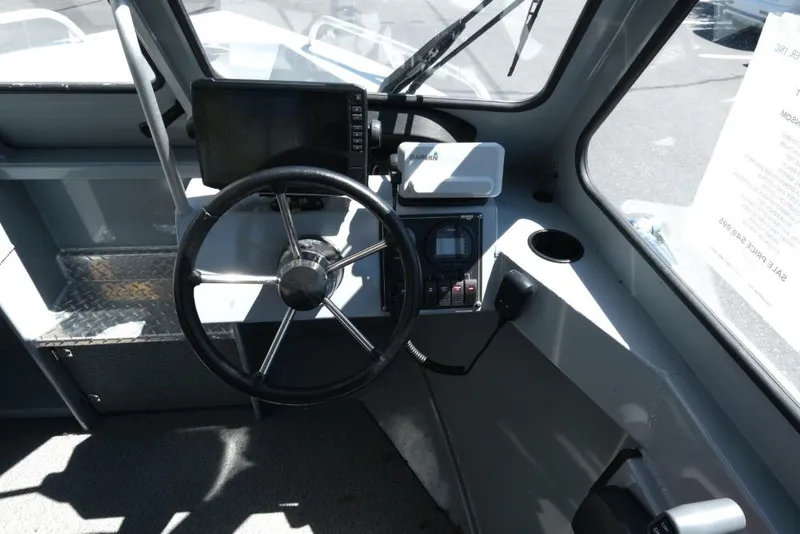 Slide: The Image of 2019 Hewescraft 200 ProV boat cockpit with steering wheel and navigation equipment. - 13