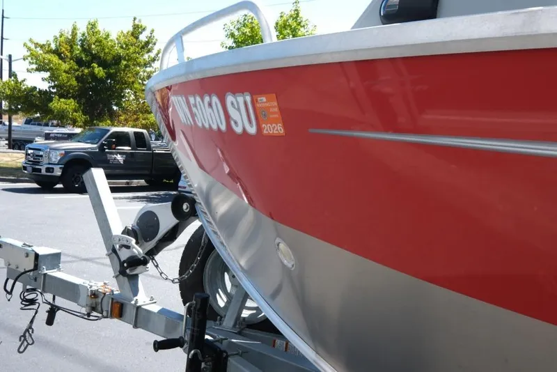 Slide: The Image of 2019 Hewescraft 200 ProV boat on trailer, red hull, parked near truck. - 17