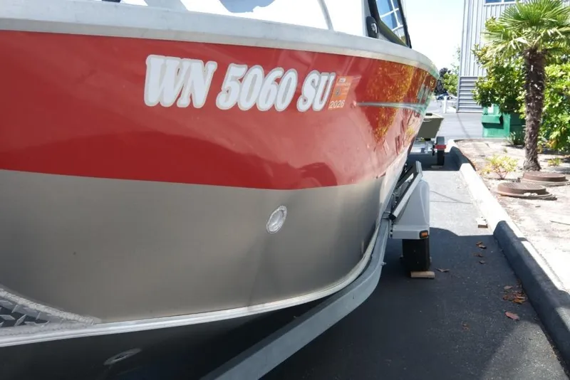 Slide: The Image of 2019 Hewescraft 200 ProV boat with red and silver exterior parked on a trailer. - 18