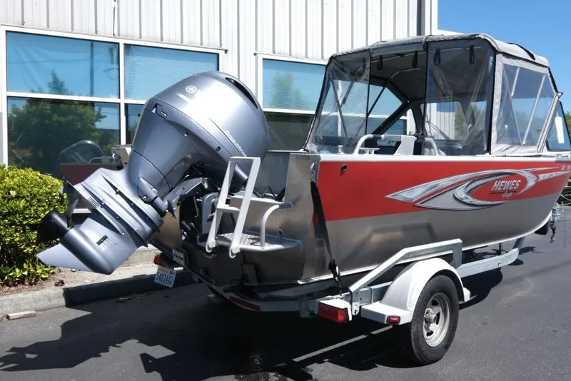 Slide: The Image of 2019 Hewescraft 200 ProV boat with outboard motor on trailer, parked outdoors. - 4