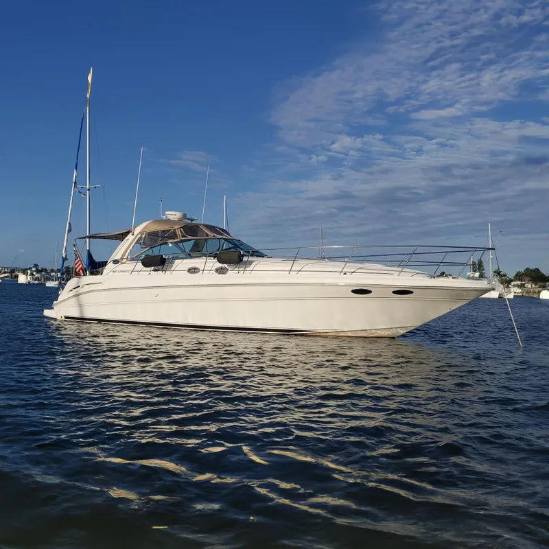 The Image of 2003 Sea Ray 410 Express Cruiser yacht on calm water under blue sky. - 0