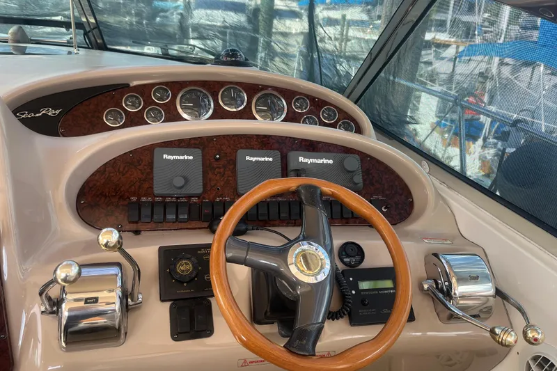 Slide: The Image of 2003 Sea Ray 410 Express Cruiser helm with Raymarine electronics and wooden steering wheel. - 5