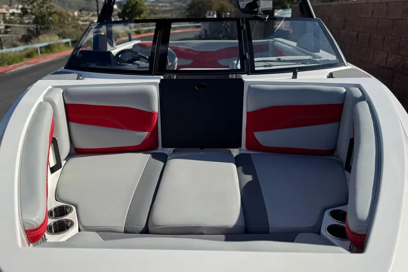 Slide: The Image of 2023 Axis T220 boat interior with red and gray seating, cup holders, and windshield. - 15