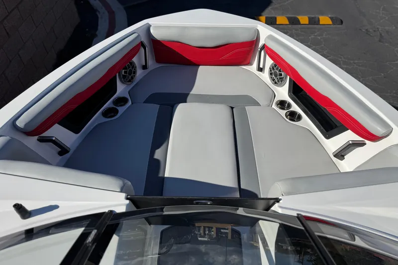 Slide: The Image of 2023 Axis T220 boat interior with red and gray seating, cup holders, and speakers. - 16