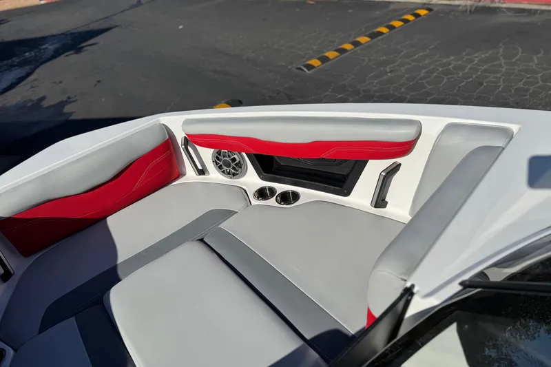 Slide: The Image of 2023 Axis T220 boat interior with red and gray seating, speaker, and cup holders. - 18