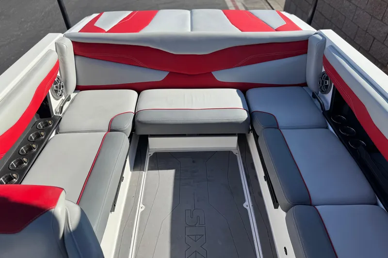 Slide: The Image of 2023 Axis T220 boat interior with red and gray seating, featuring cup holders and speakers. - 20