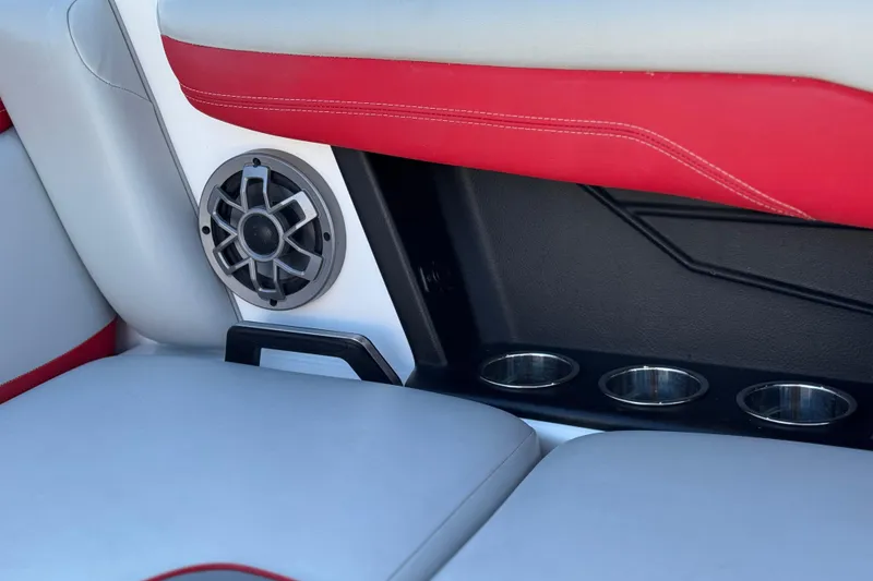 Slide: The Image of 2023 Axis T220 boat interior with speaker and cup holders, featuring red and white seating. - 26