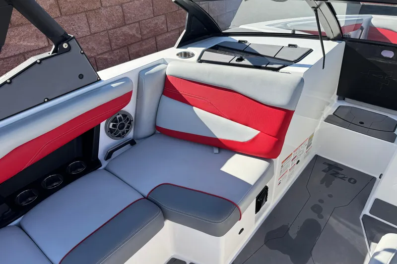 Slide: The Image of 2023 Axis T220 boat interior with red and gray seating, speaker, and cup holders. - 27