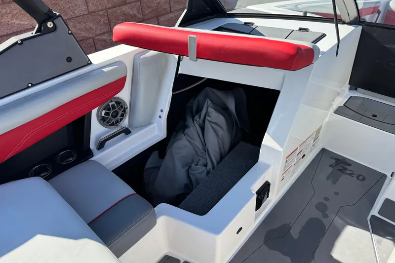 Slide: The Image of 2023 Axis T220 boat interior with red accents and storage compartment open. - 28