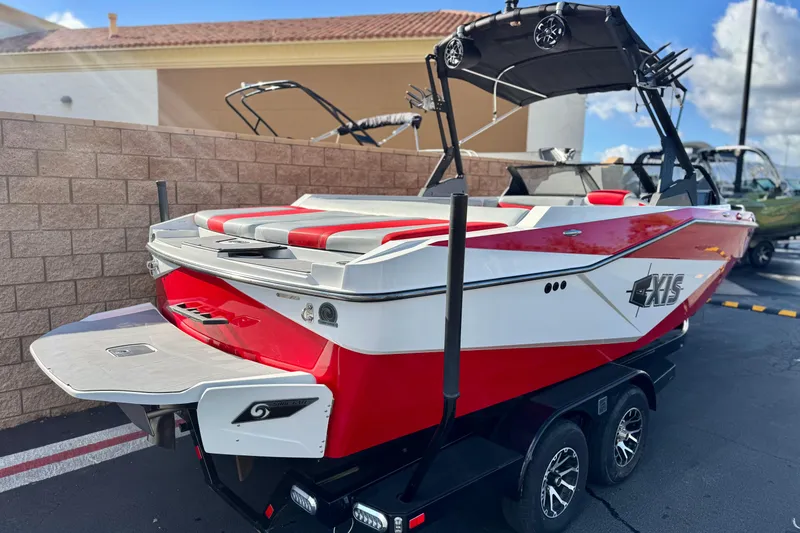 Slide: The Image of 2023 Axis T220 boat with red and white design, parked on a trailer. - 5