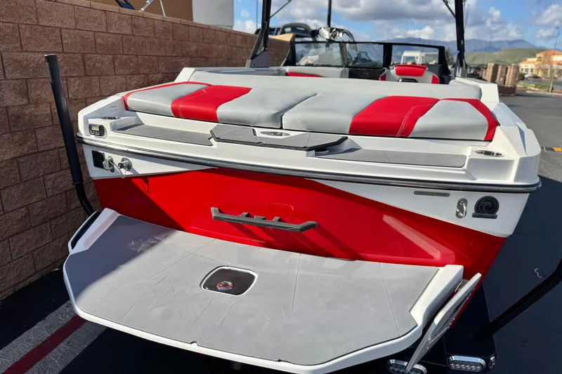 Slide: The Image of 2023 Axis T220 boat with red and gray seating, docked outdoors. - 6