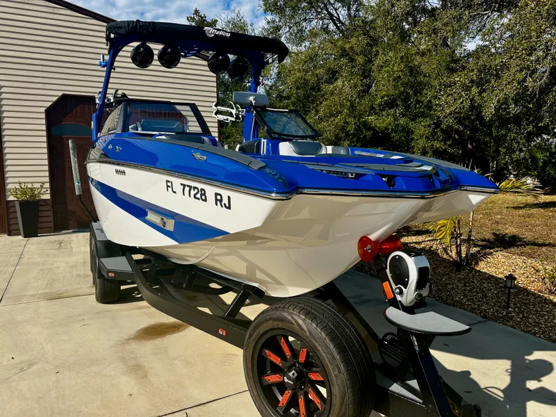 Slide: The Image of 2017 Malibu M235 boat on trailer in sunny setting. - 1