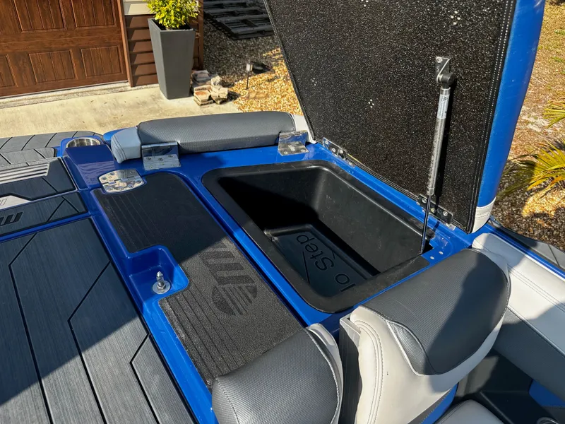 Slide: The Image of 2017 Malibu M235 boat with open storage compartment lid. - 27