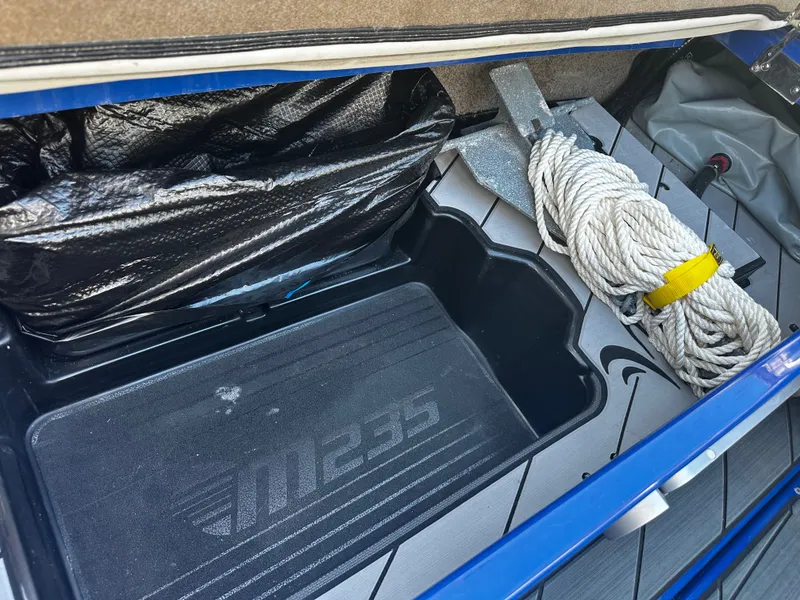 Slide: The Image of Storage compartment in 2017 Malibu M235 boat with rope and anchor. - 36
