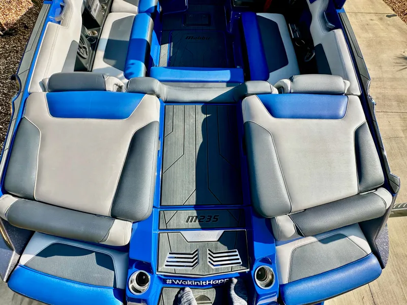 Slide: The Image of Interior of a 2017 Malibu M235 boat with blue and gray seating. - 7