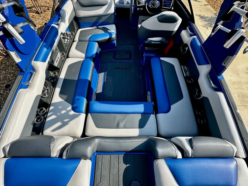 Slide: The Image of Interior of a 2017 Malibu M235 boat with blue and gray seating. - 8