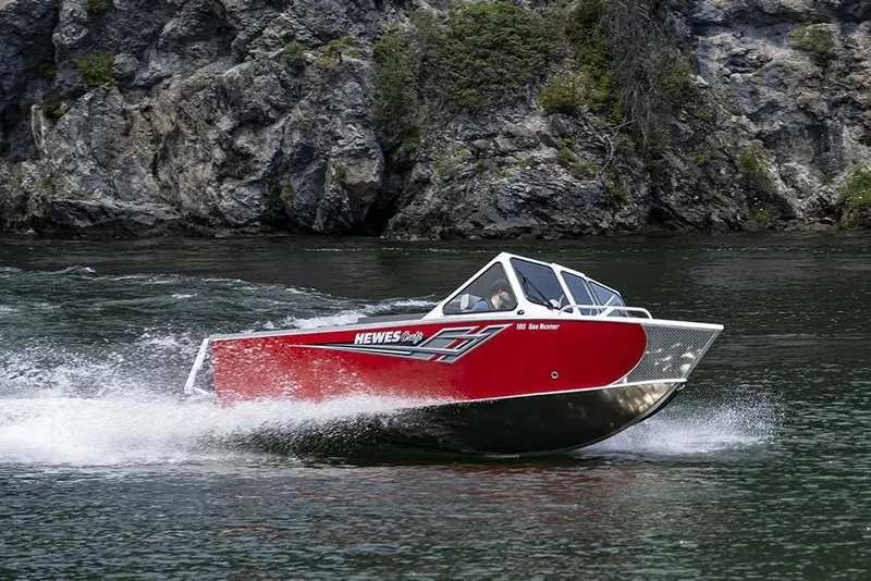 Slide: The Image of 2026 Hewescraft 190 Sea Runner ET boat cruising on a scenic river. - 29