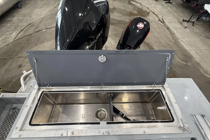 Slide: The Image of Open storage compartment on 2026 Hewescraft 190 Sea Runner ET boat, with visible outboard motors. - 8