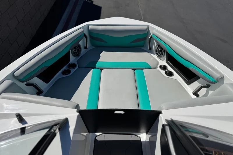 Slide: The Image of 2023 Axis T220 boat interior with teal and gray seating, cup holders, and speakers. - 11