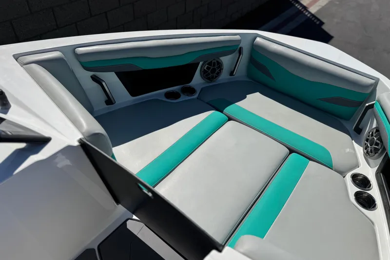 Slide: The Image of Interior of 2023 Axis T220 boat with teal and gray seating, cup holders, and speakers. - 12