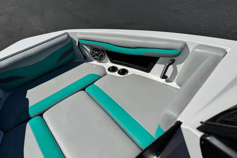Slide: The Image of 2023 Axis T220 boat interior with teal and gray seating, cup holders, and speaker. - 13