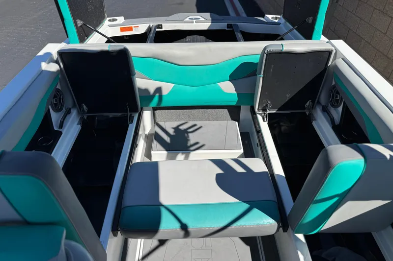 Slide: The Image of 2023 Axis T220 boat interior with teal and gray seating, open storage compartments. - 19