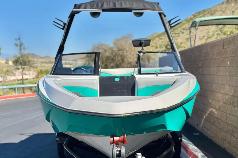 Slide: The Image of 2023 Axis T220 boat with sleek design, parked outdoors on a sunny day. - 2