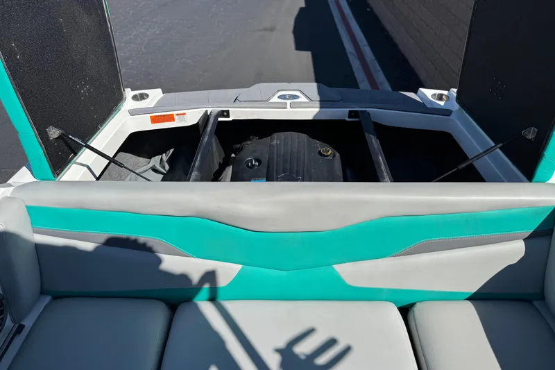 Slide: The Image of 2023 Axis T220 boat engine compartment with teal and gray seating. - 20