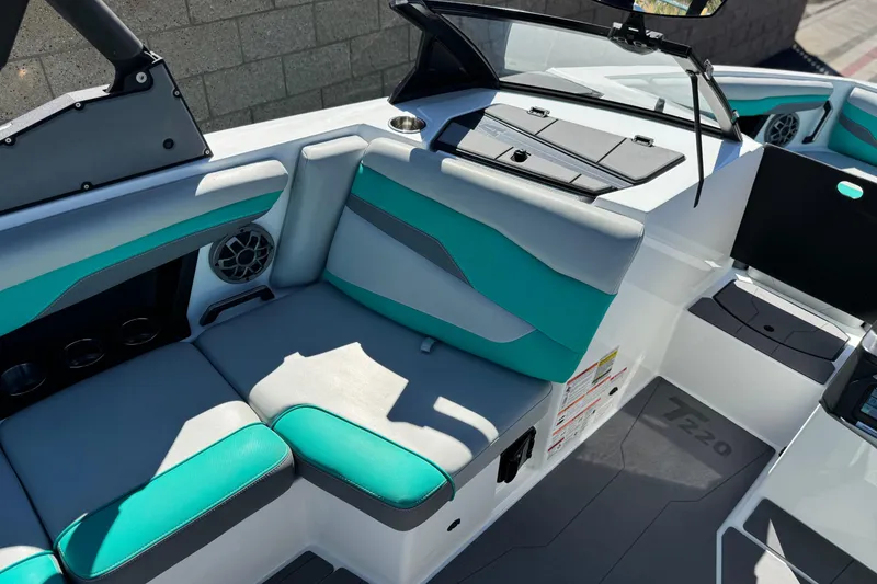 Slide: The Image of 2023 Axis T220 boat interior with teal and gray seating, cup holders, and dashboard. - 23