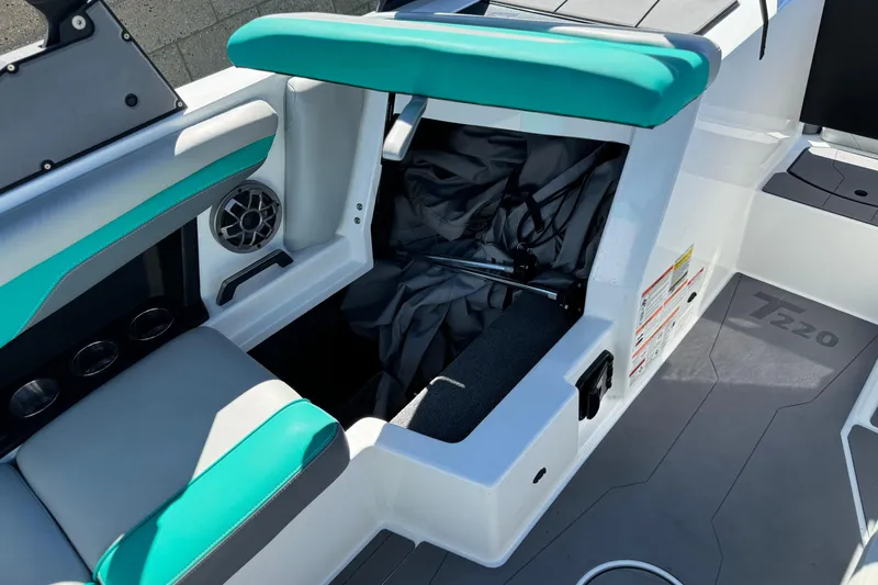 Slide: The Image of 2023 Axis T220 boat interior with teal seating and storage compartment open. - 24