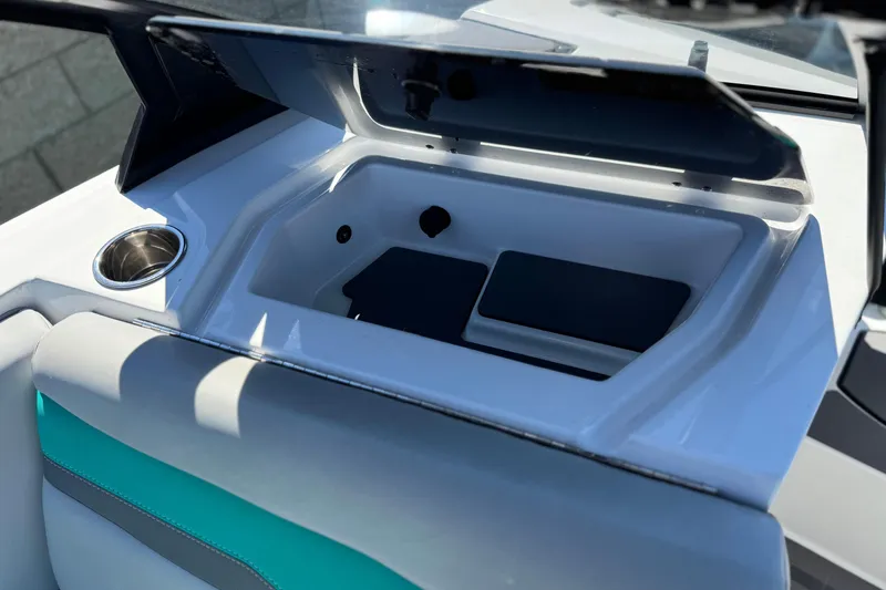 Slide: The Image of 2023 Axis T220 boat storage compartment with open lid and cup holder. - 25