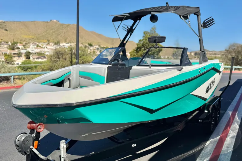 Slide: The Image of 2023 Axis T220 boat with sleek design, parked on a trailer, scenic background. - 3