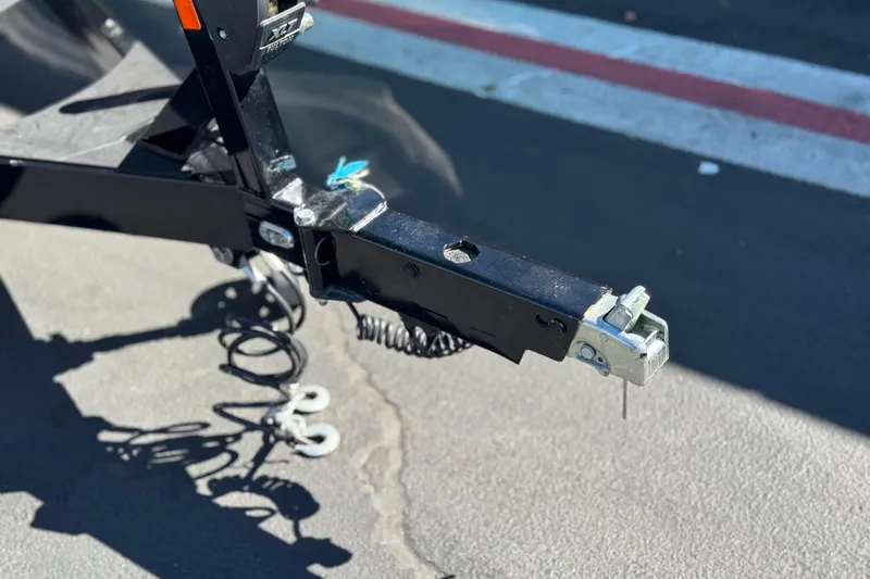 Slide: The Image of Trailer hitch of 2023 Axis T220 on asphalt, featuring coiled safety cables. - 35