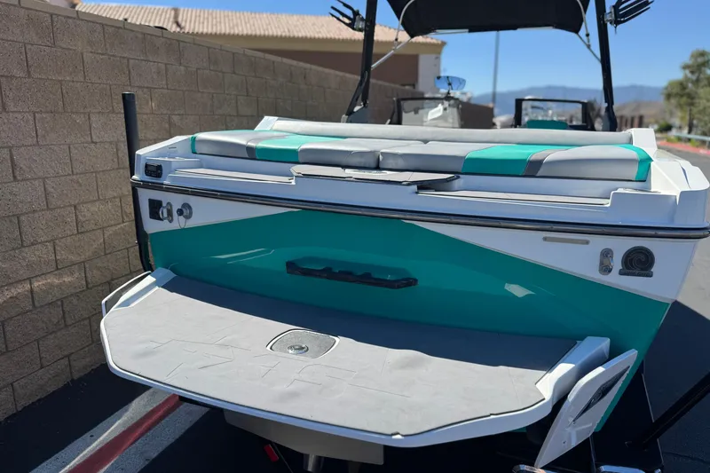 Slide: The Image of 2023 Axis T220 boat with teal and white design, rear view. - 6