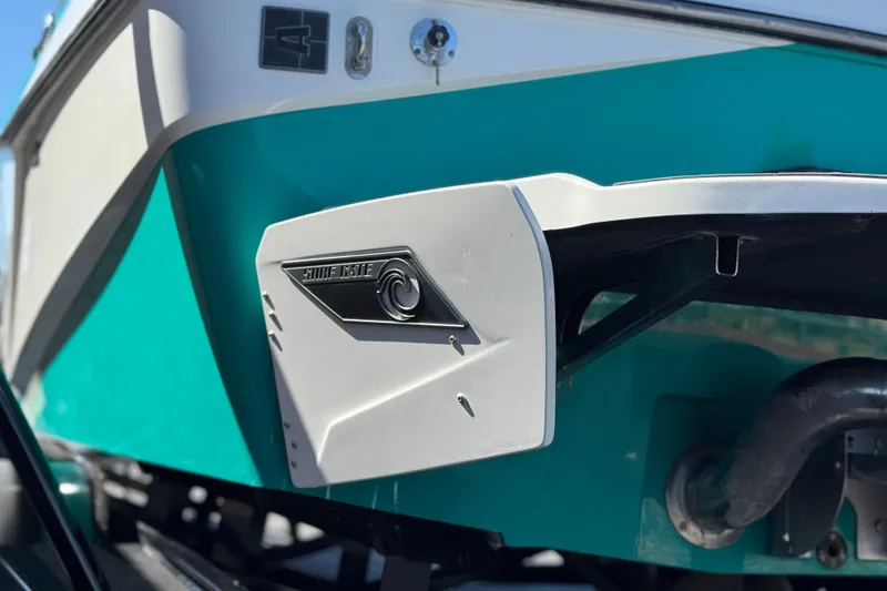 Slide: The Image of 2023 Axis T220 boat with Surf Gate feature, teal and white exterior. - 8
