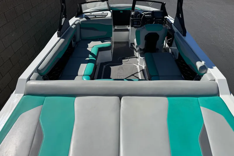 Slide: The Image of 2023 Axis T220 boat interior with teal and gray seating, modern dashboard, and spacious layout. - 9