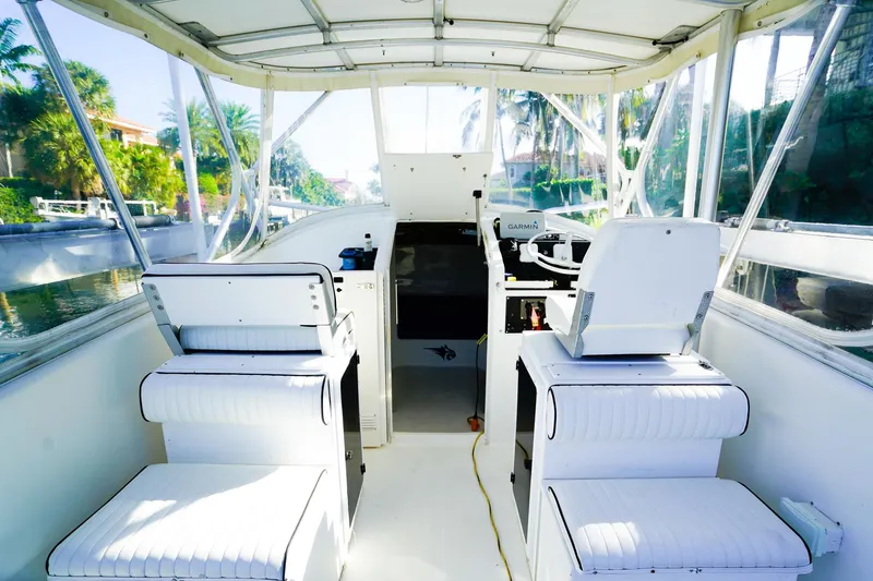 Slide: The Image of Interior of 2000 Powercat 30 Ope boat with white seating and steering console. - 11