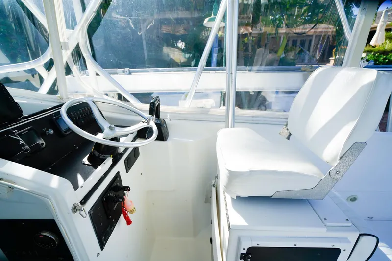 Slide: The Image of Interior of a 2000 Powercat 30 Ope boat, featuring steering wheel and white seating. - 14
