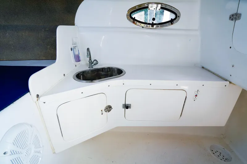 Slide: The Image of Interior of 2000 Powercat 30 Ope boat with sink and storage compartments. - 18