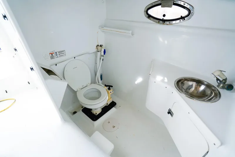 Slide: The Image of Powercat 30 Ope 2000 boat bathroom with toilet, sink, and porthole window. - 20