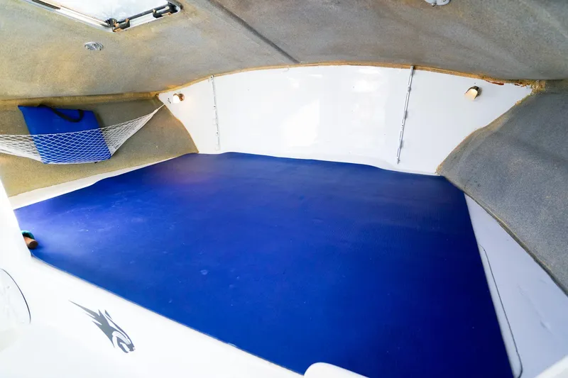 Slide: The Image of Interior cabin of a 2000 Powercat 30 OPE boat with blue mat and storage net. - 21