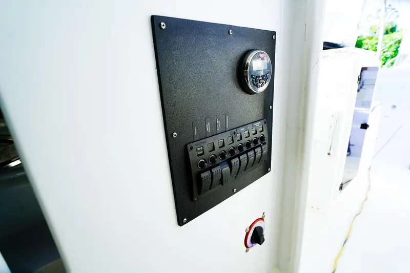 Slide: The Image of Control panel on a 2000 Powercat 30 Ope boat, featuring switches and a gauge. - 23