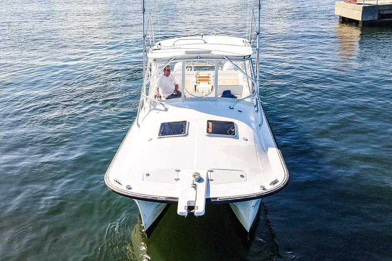 Slide: The Image of Powercat 30 Ope 2000 boat on calm water, viewed from the front. - 28
