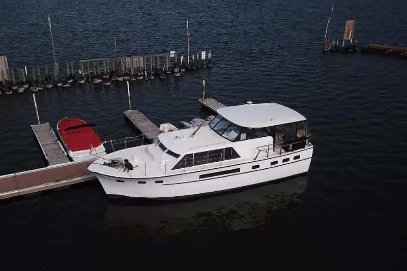 Slide: The Image of 1967 Hatteras 44 Tri Cabin yacht with dinghy, docked on a sunny day. - 2