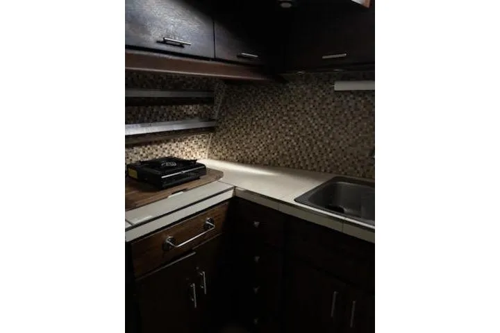 Slide: The Image of 1967 Hatteras 44 Tri Cabin kitchen with dark wood cabinets and mosaic backsplash. - 20