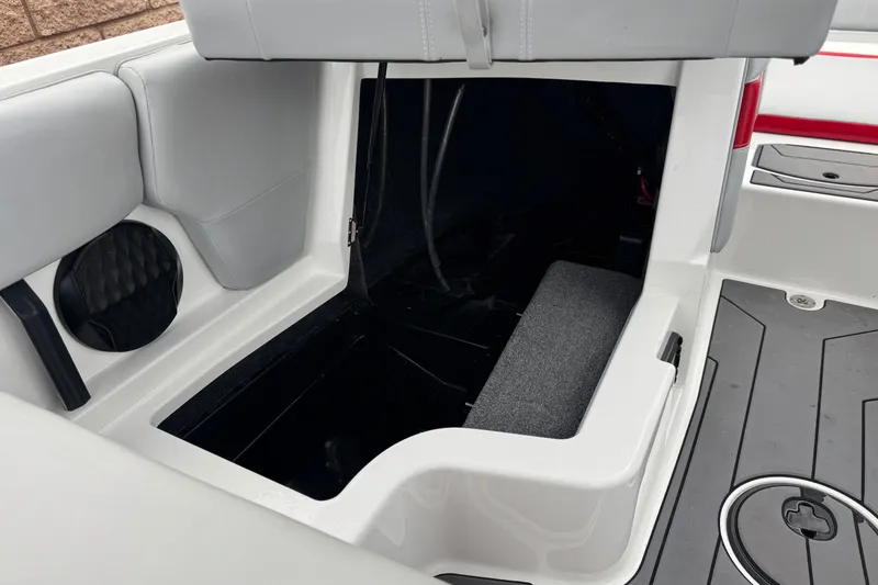 Slide: The Image of 2023 Malibu Wakesetter 21 LX interior storage compartment with gray seating and speaker. - 25