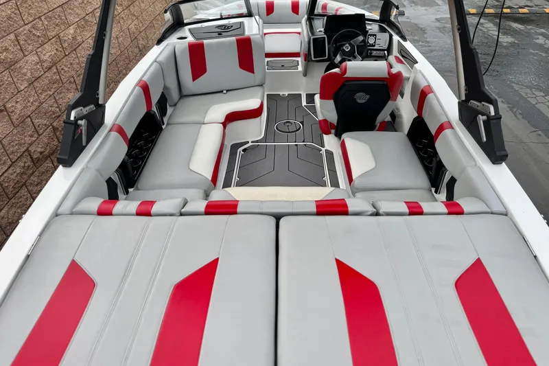 Slide: The Image of 2023 Malibu Wakesetter 21 LX interior with red and gray seating, modern dashboard. - 9
