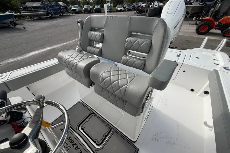 Slide: The Image of 2026 Blazer Bay Makaira 2600 boat interior with luxurious gray seating and steering wheel. - 16