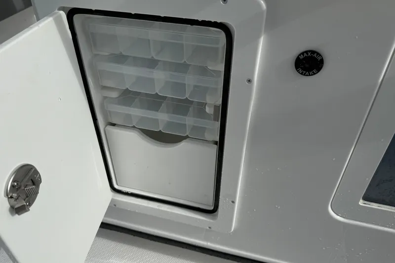 Slide: The Image of Open storage compartment on 2026 Blazer Bay Makaira 2600 boat with tackle boxes. - 23